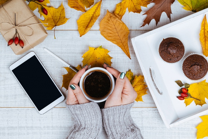 hands holding coffee with mobile phone and muffins