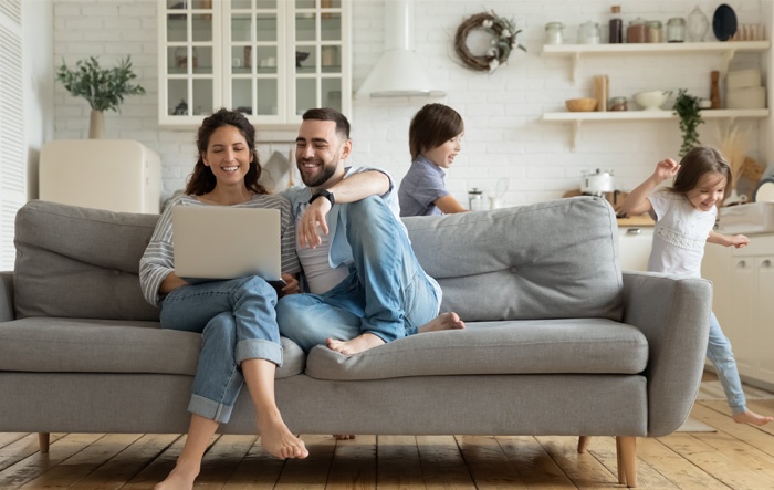 couple joining greylock federal credit union membership online while kids run around